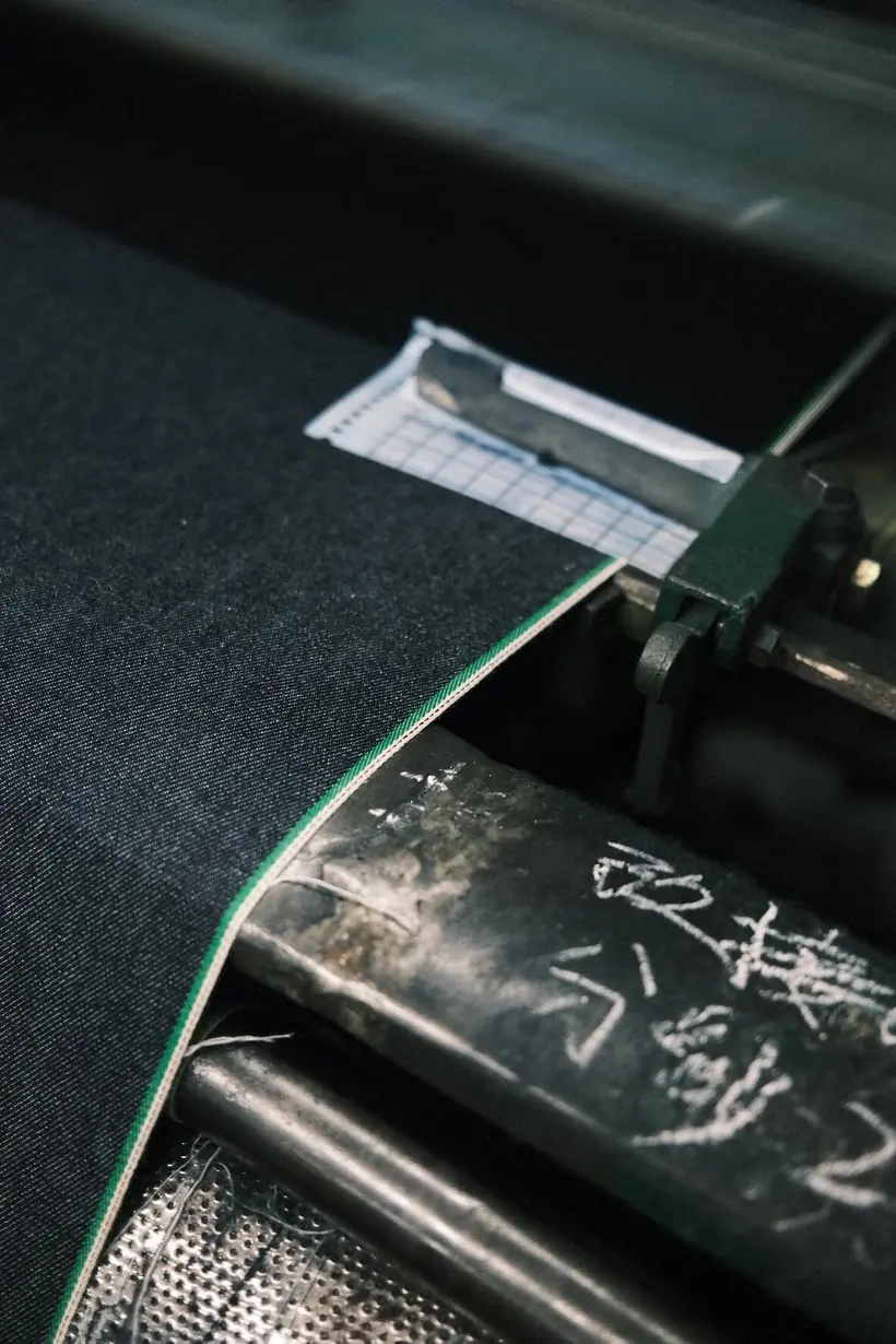 Green selvedge edge on dark indigo denim fabric woven on a loom